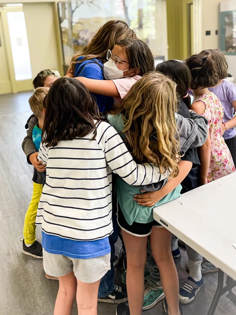 Campers in a group hug inside the studio